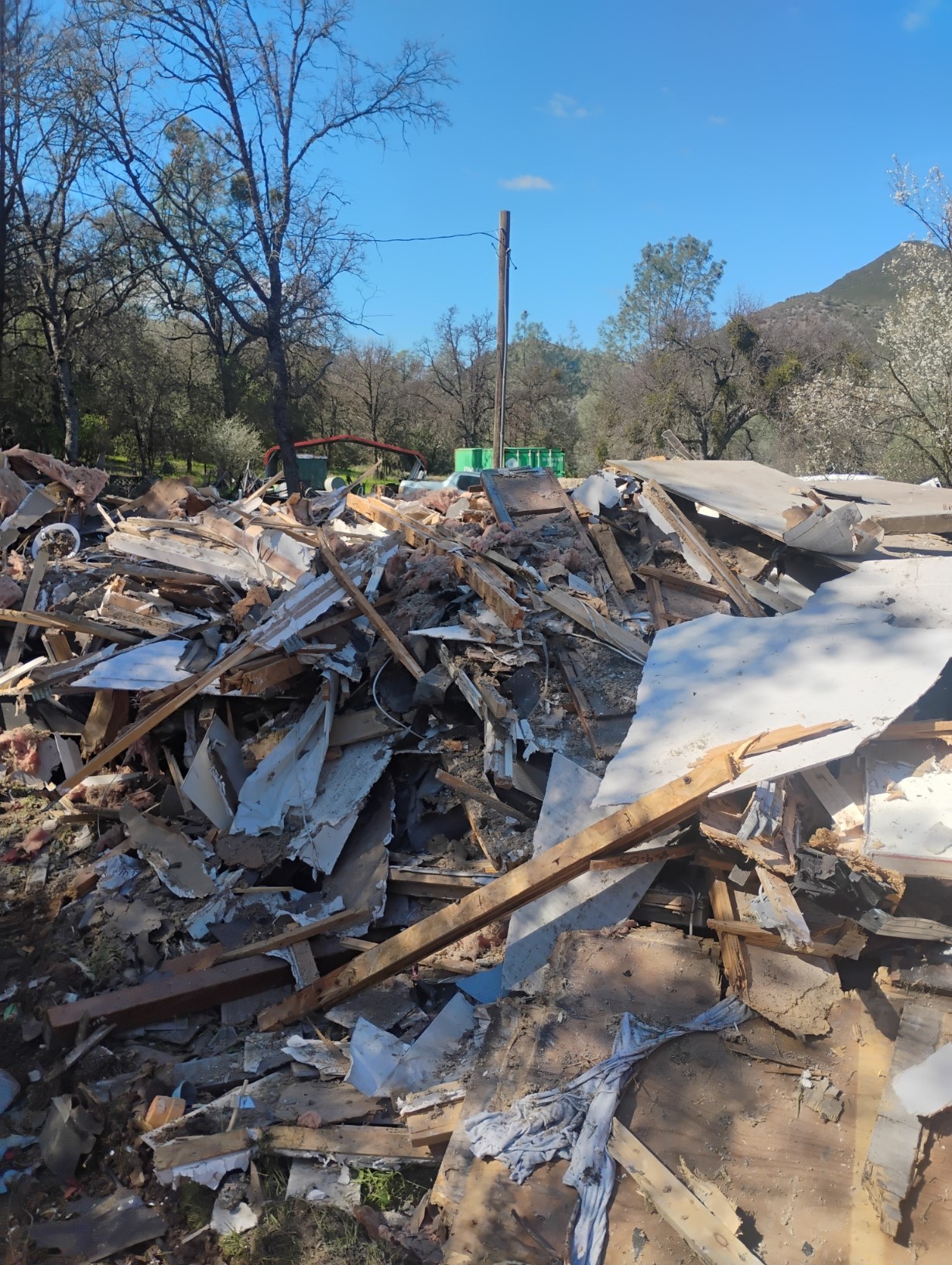Demolition debris pile during structure removal in Coulterville Mariposa County CA