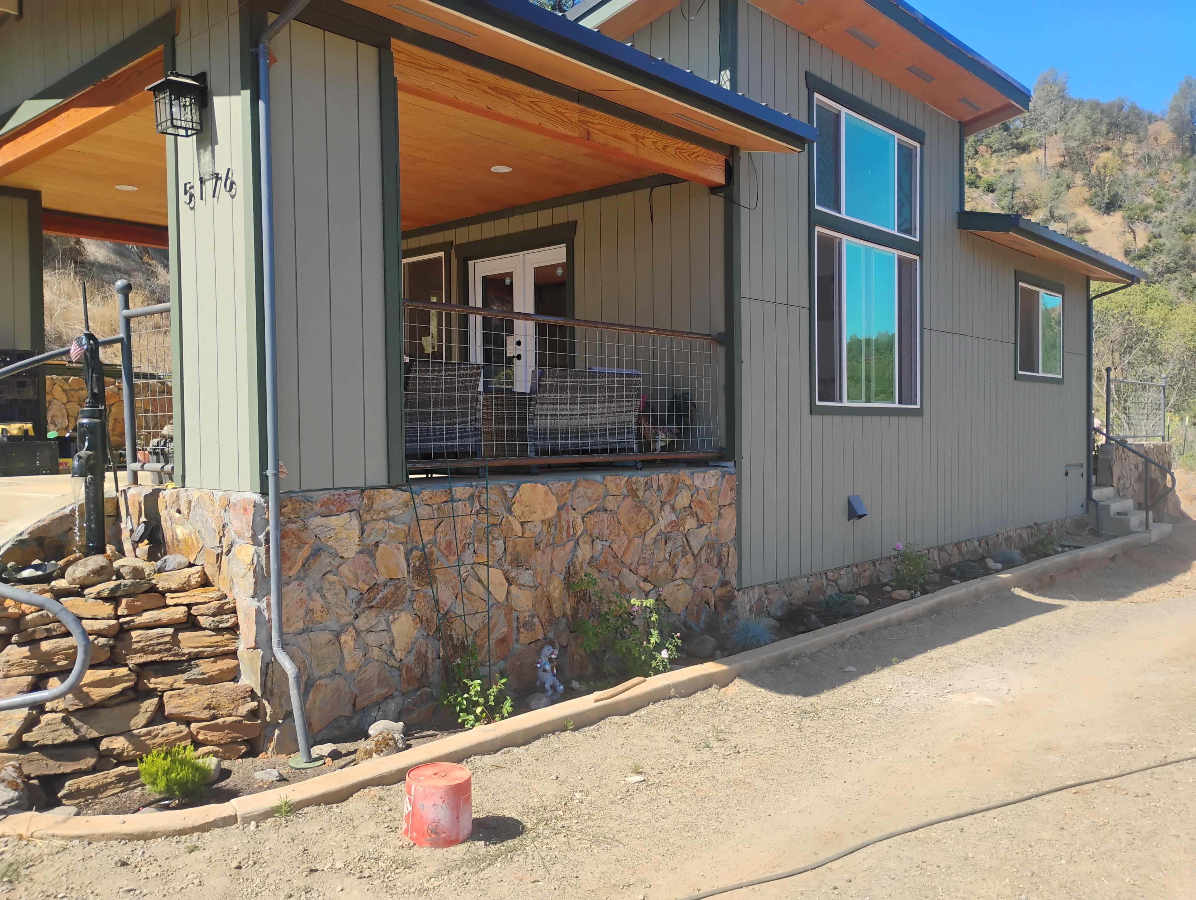 Custom home exterior siding and stone hillside project by DCB