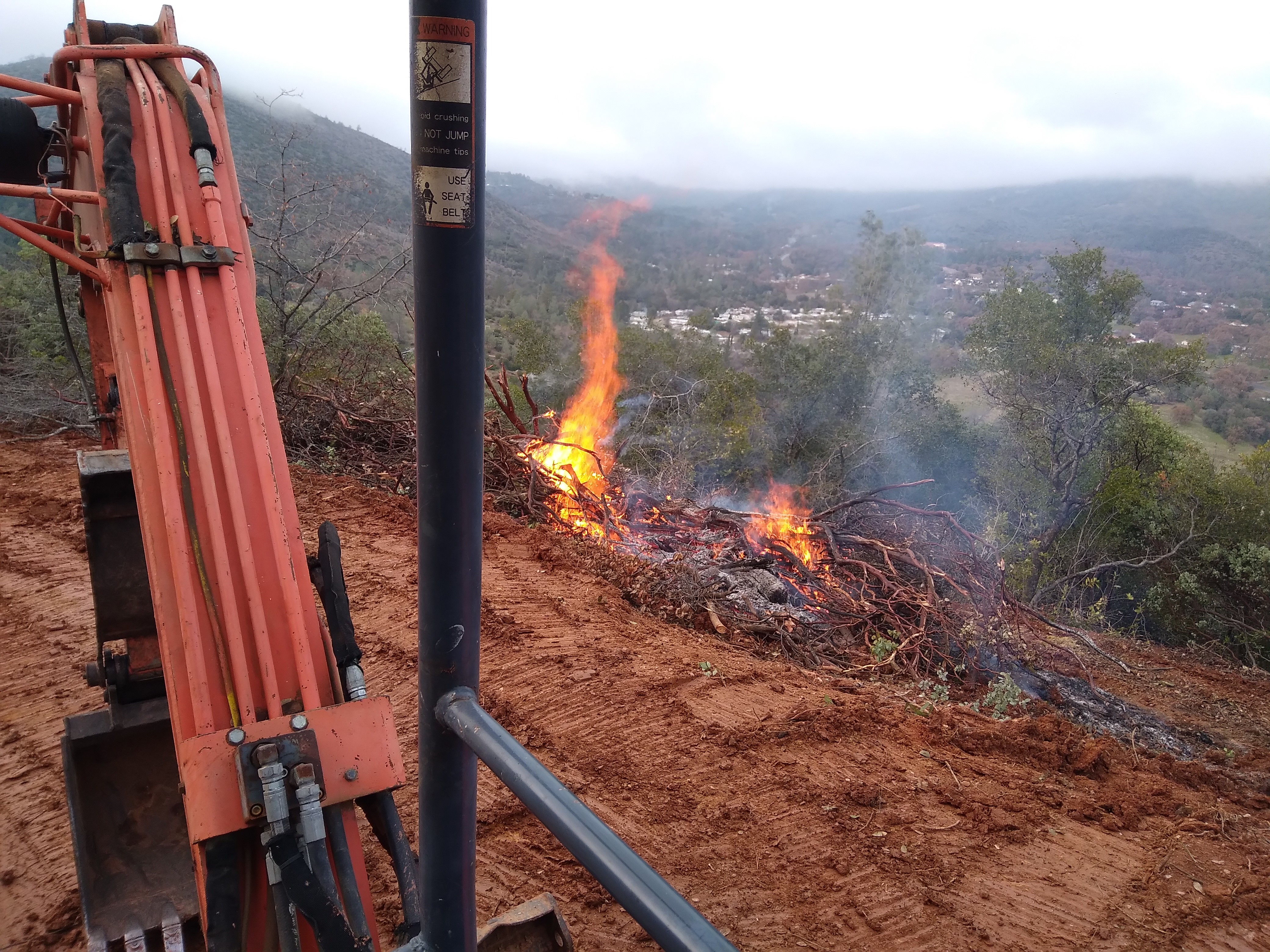 Land clearing burn pile on hillside property in Mariposa CA